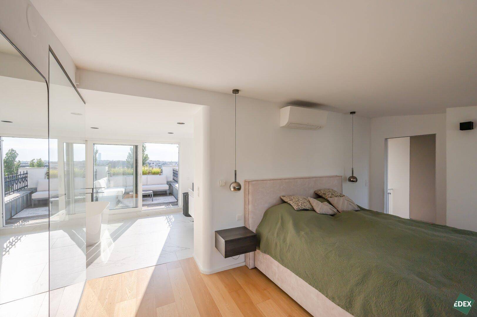 Helles Schlafzimmer mit Doppelbett, Klimaanlage und direktem Terrassenzugang.