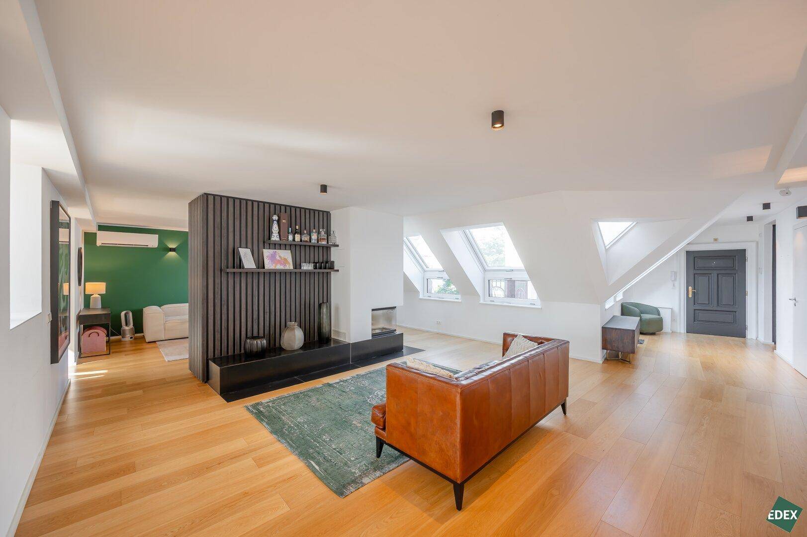 Gemütliches Wohnzimmer mit Holzboden, Dachfenstern und dekorativer Wandgestaltung.