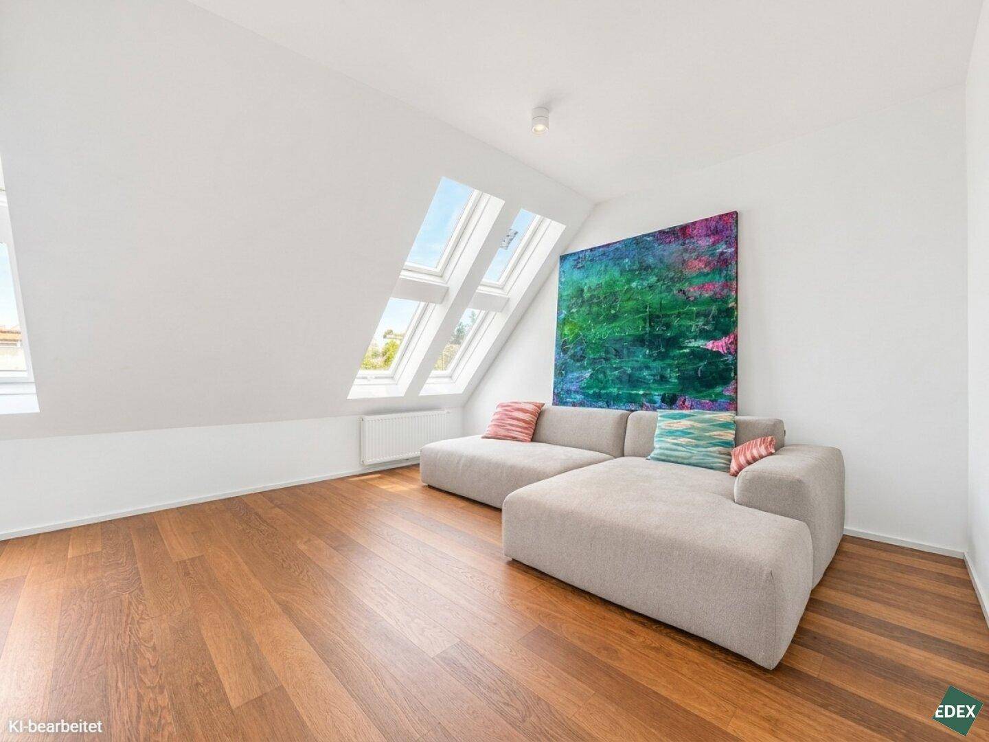 Gemütliches Wohnzimmer im Dachgeschoss mit Sofa, Kunstwerk und viel natürlichem Licht.