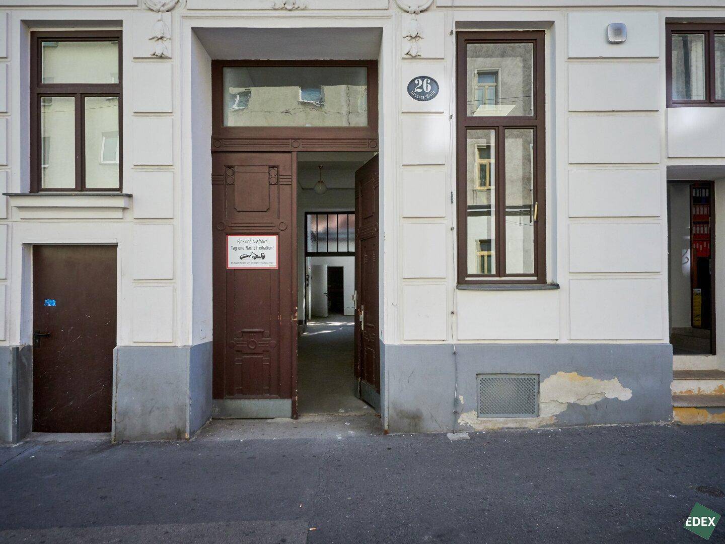 Historische Fassade eines Gebäudes mit brauner Eingangstür und Fenstern, Hausnummer 26.