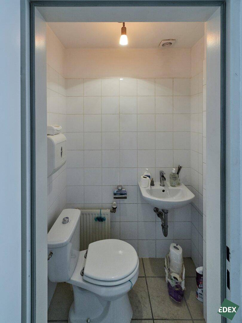Kleiner Toilettenraum mit WC und Handwaschbecken, einfach gefliest und funktional.