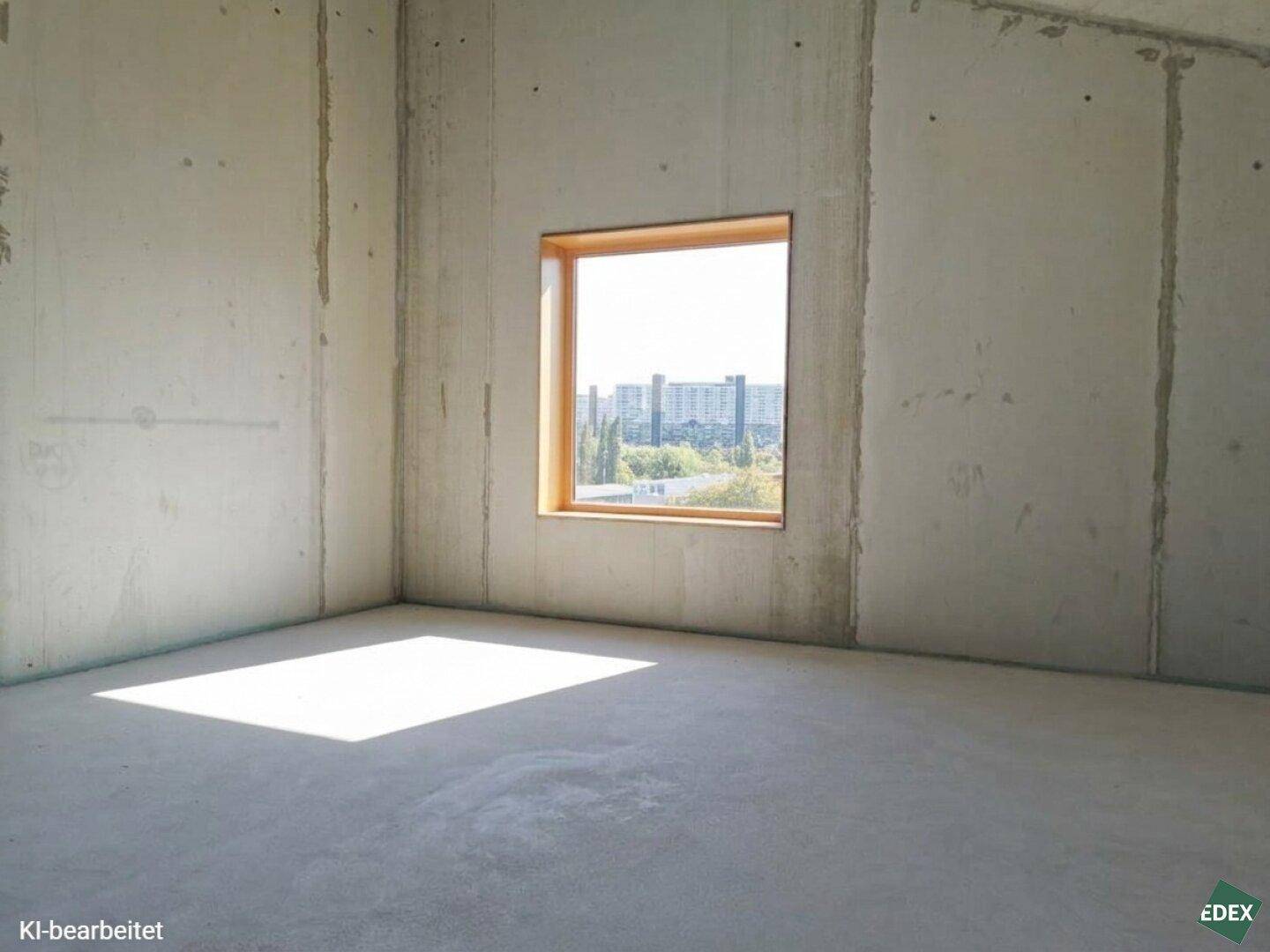 Heller, leerer Raum mit Sichtbetonwänden und einem Fenster, das viel Tageslicht hereinlässt.