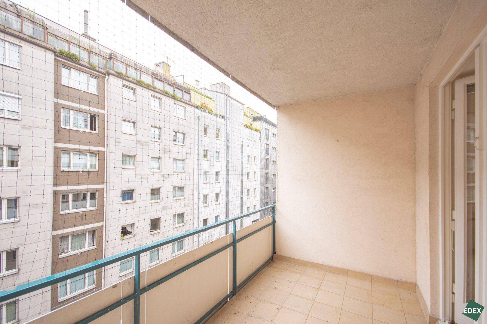 Geräumiger Balkon mit Fliesenboden und einem weiten Blick auf die Stadtbebauung.