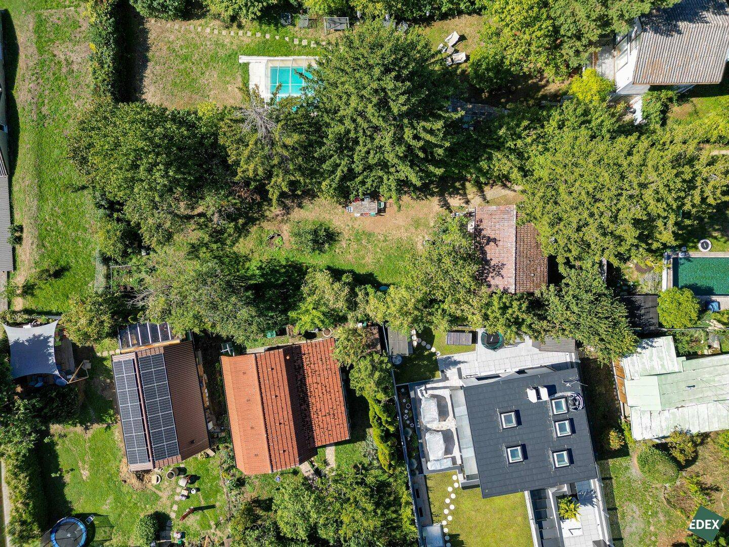 Vogelperspektive des Grundstücks mit Garten und umliegender Wohnbebauung, umgeben von viel Grün.