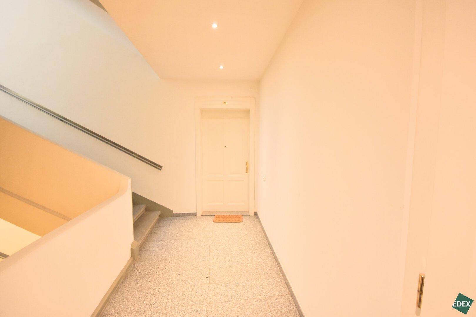 Eingangsbereich des Gebäudes mit Treppenhaus und Zugang zur Wohnung.