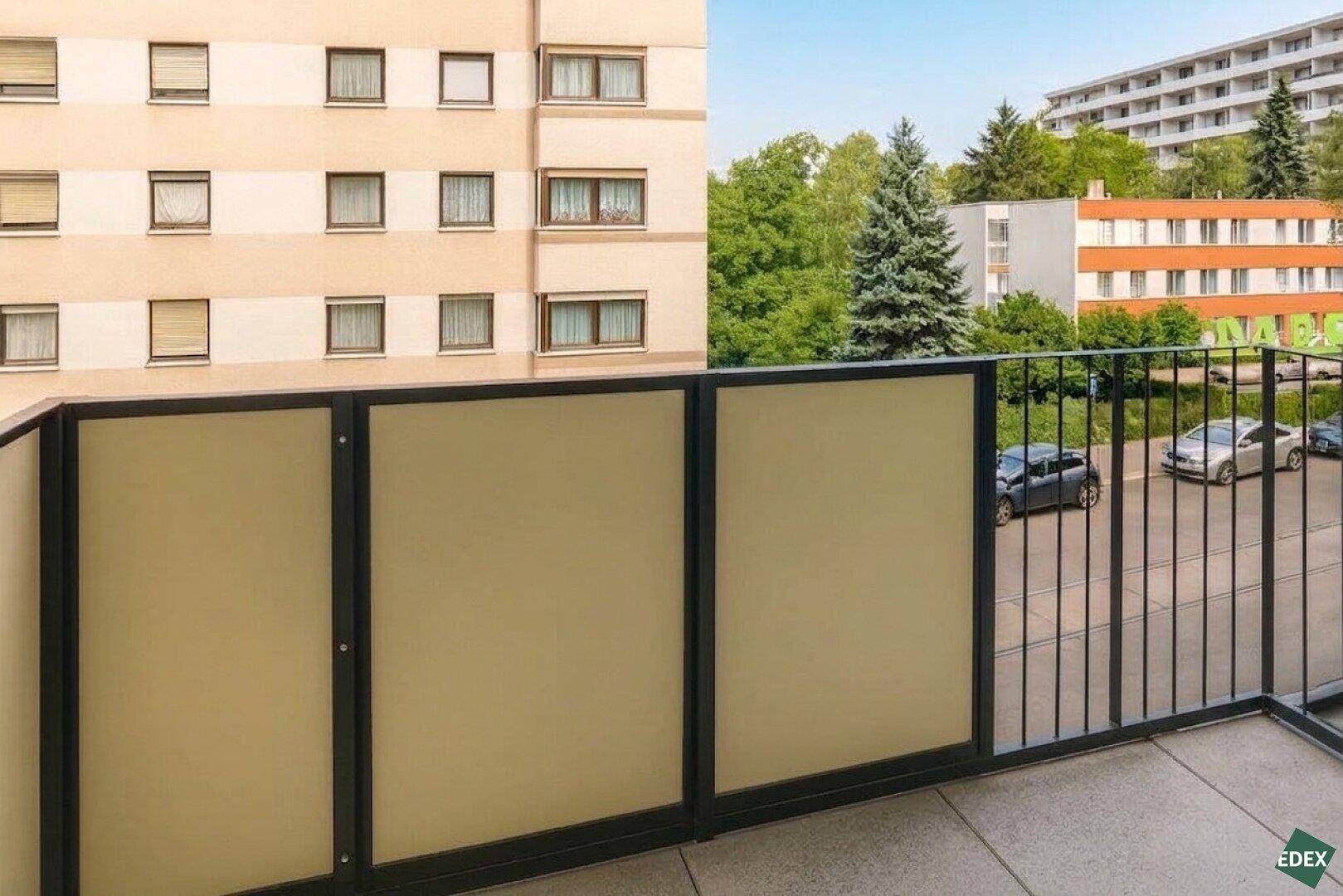 Balkon mit Blick auf die umliegende Wohnbebauung und viel Grün.