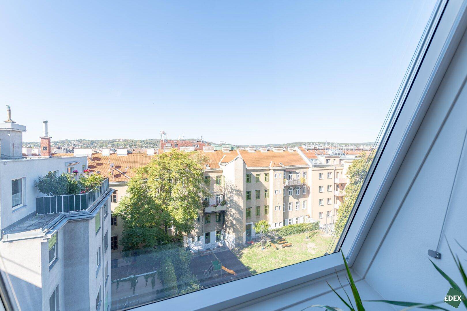 Weitläufiger Blick aus dem Dachfenster auf die Stadt und die umliegende Landschaft.