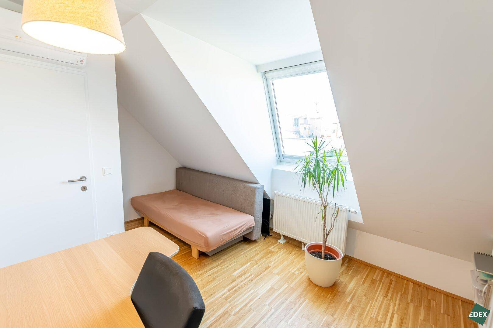 Arbeitszimmer mit Schlafsofa, Schreibtisch und Dachfenster für viel Licht.