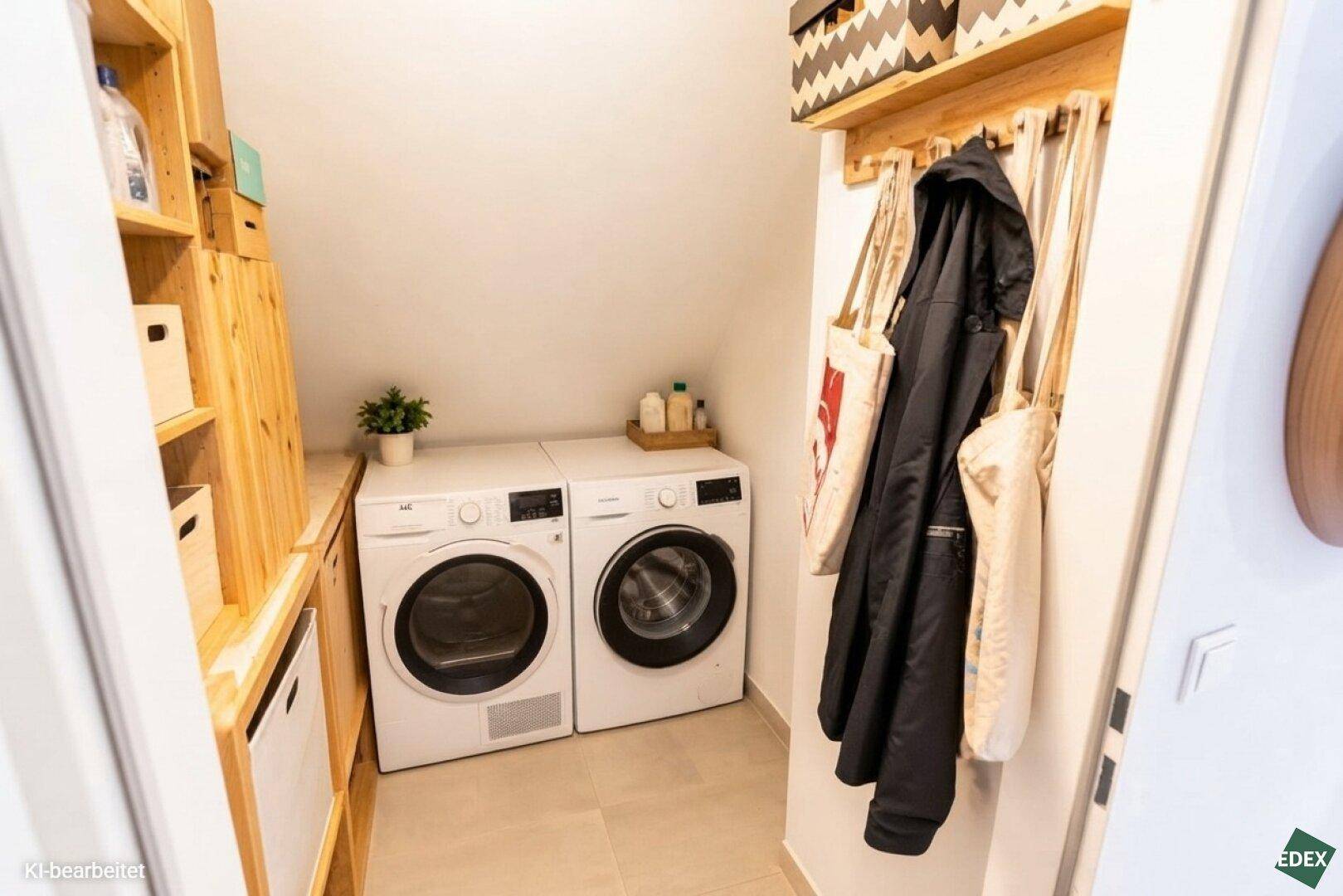 Praktischer Hauswirtschaftsraum mit Waschmaschine, Trockner und integrierten Holzregalen für zusätzlichen Stauraum.