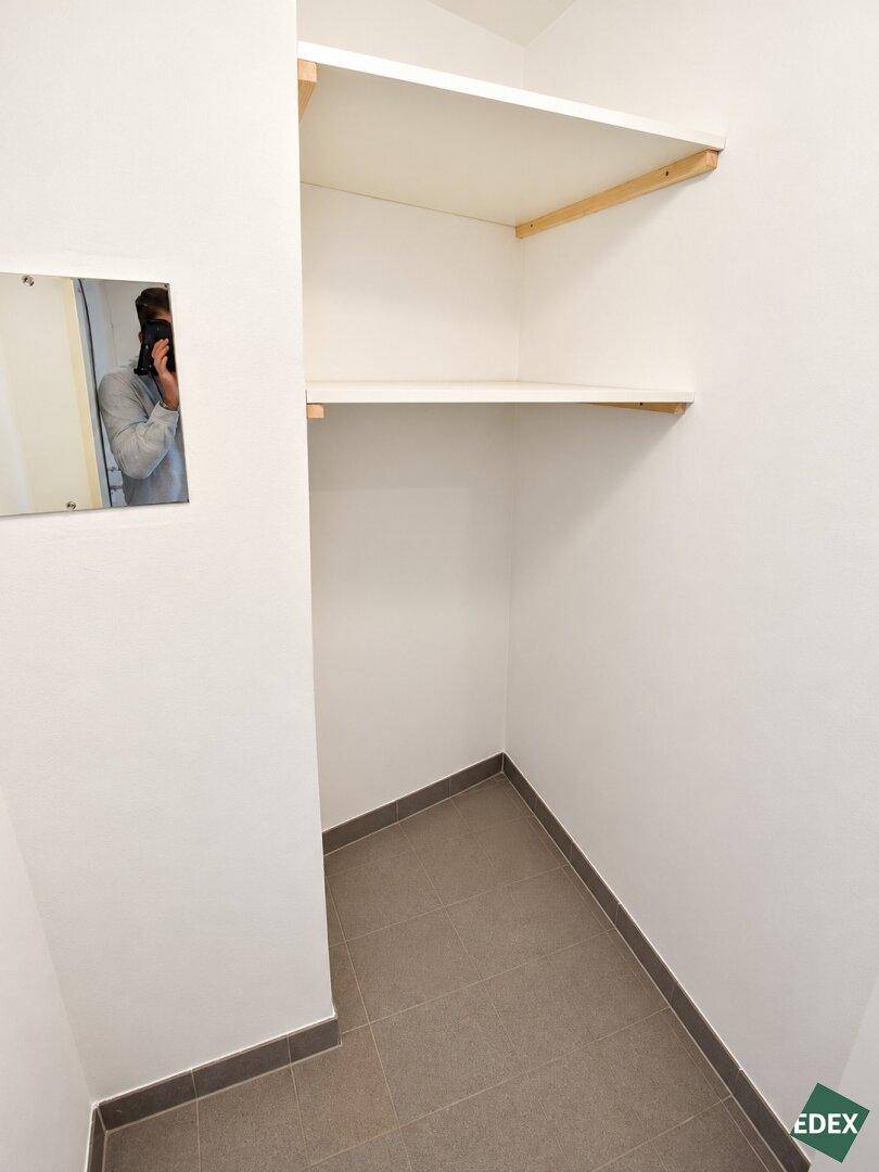 Praktischer Abstellraum mit Regalen und Fliesenboden für zusätzlichen Stauraum.