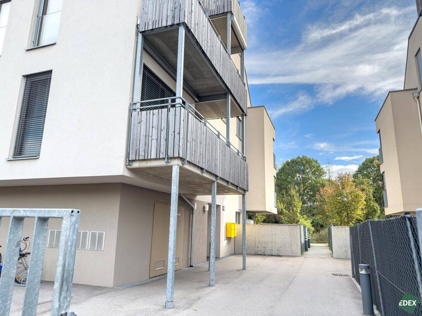 Außenansicht des modernen Gebäudes mit mehreren Balkonen und Zugangsbereichen.