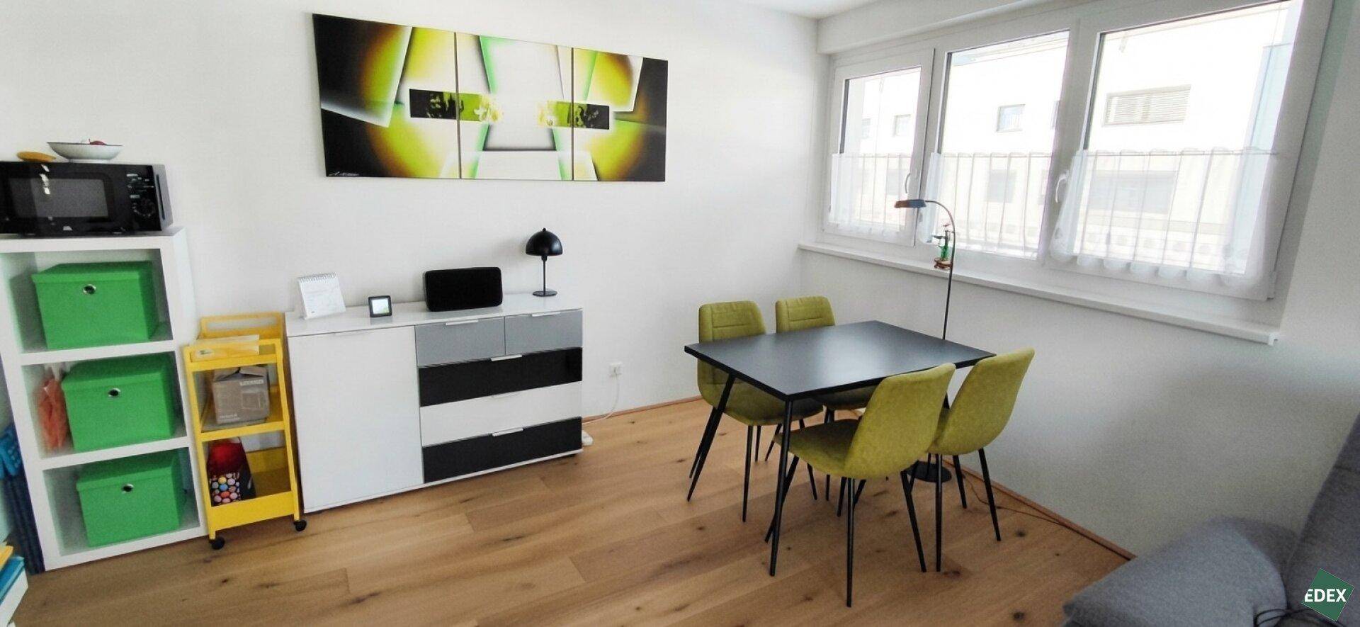 Essbereich mit modernem Tisch, gelben Stühlen und großem Fenster.