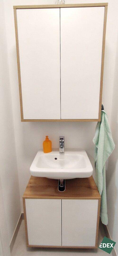 Kleines Gäste-WC mit modernem Waschtisch und Spiegelschrank.
