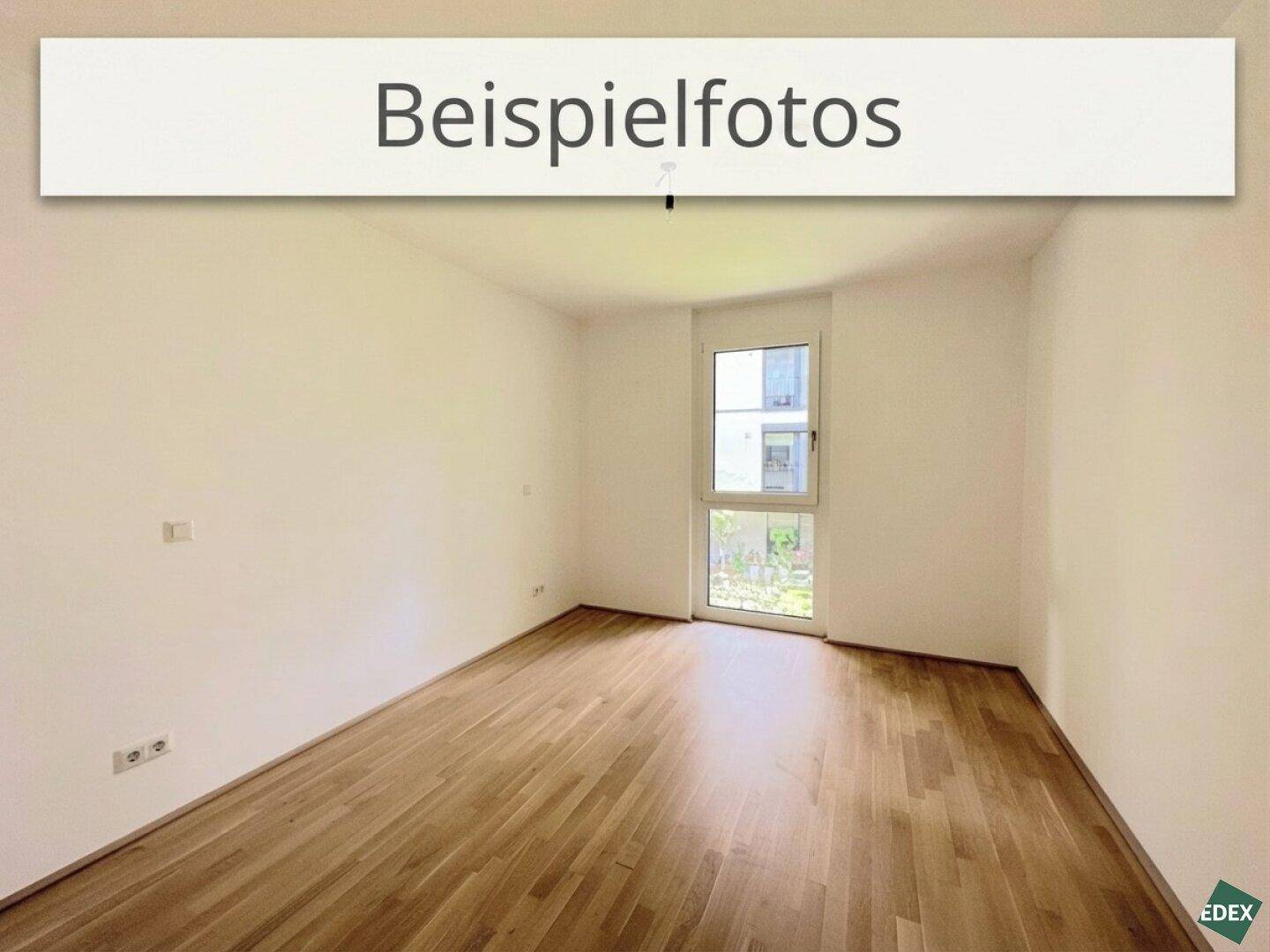 Leeres Schlafzimmer mit hellem Holzboden und einer Tür, die ins Freie führt.
