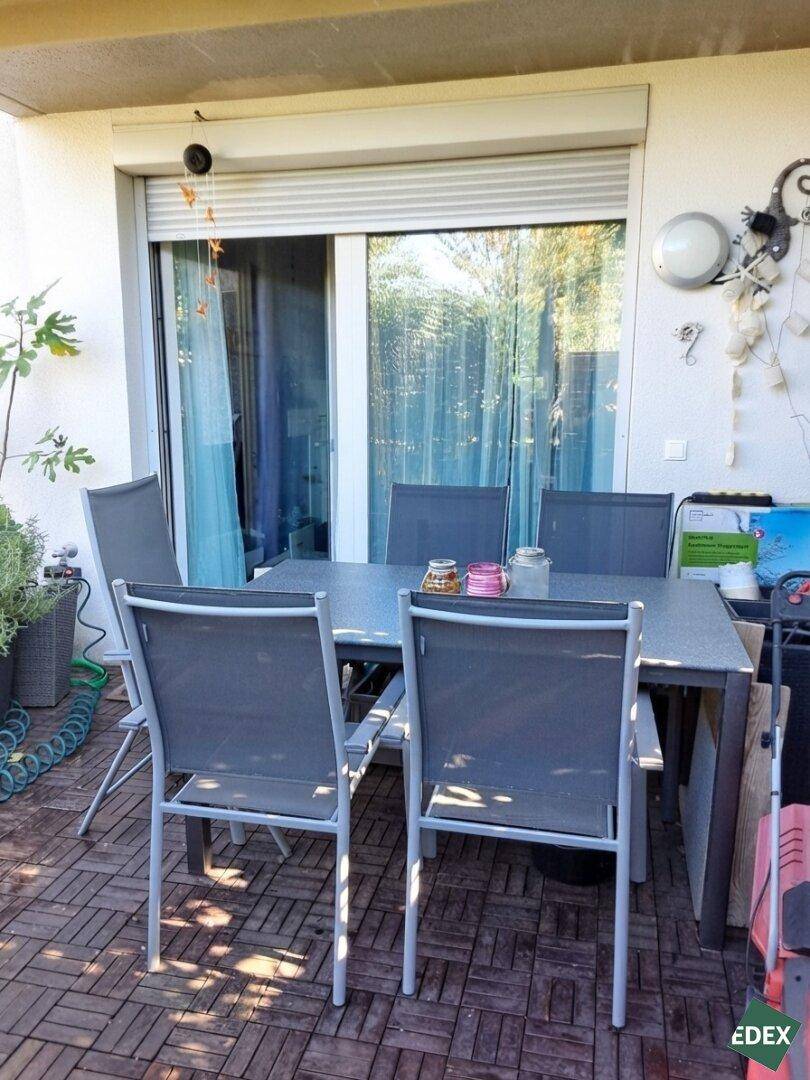 Möblierte Terrasse mit Esstisch und Stühlen, ideal für Mahlzeiten im Freien.