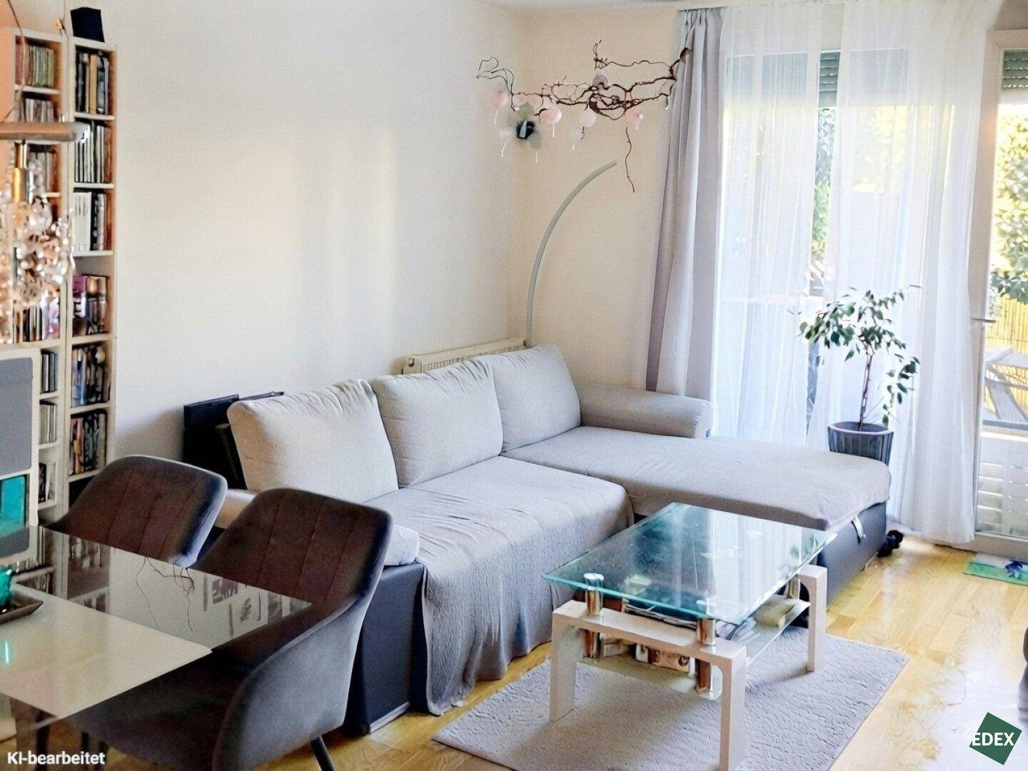 Gemütlicher Wohnbereich mit Sofa, Couchtisch und Zugang zum Außenbereich.