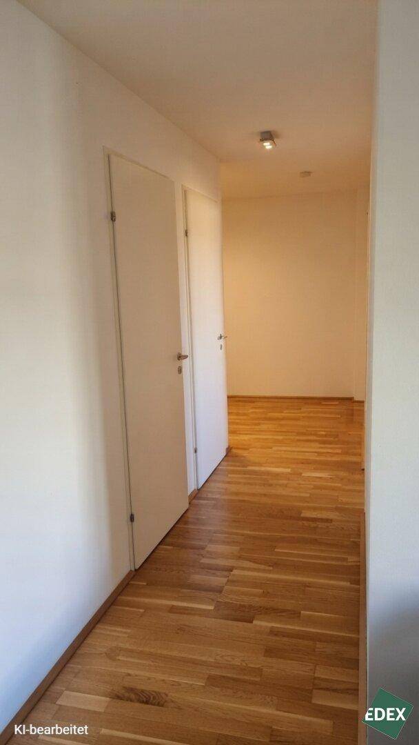 Langer, heller Flur mit Parkettboden und weißen Türen, der die Wohnbereiche verbindet.