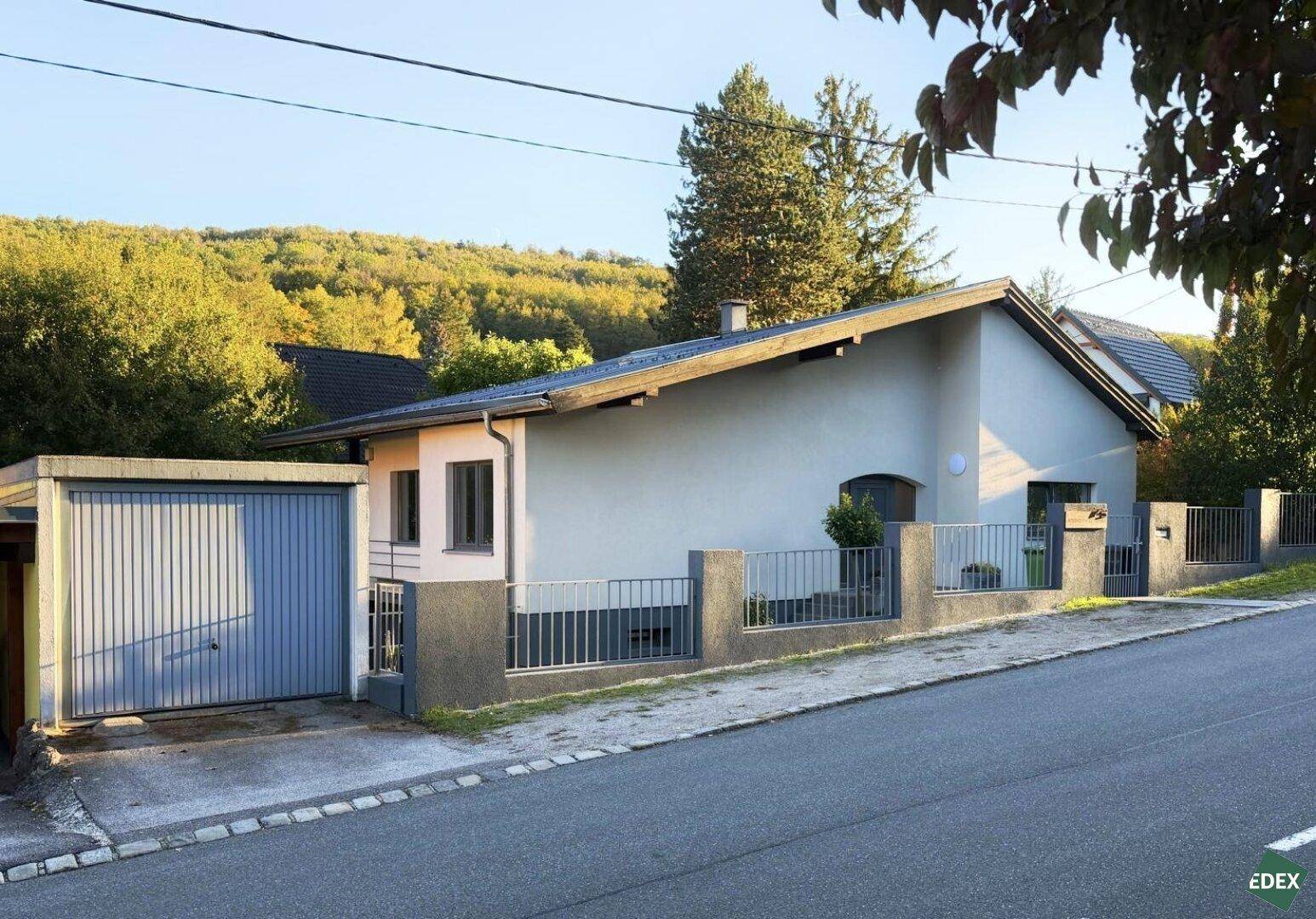 Hausansicht von der Straße mit separater Garage und gepflegtem Vorgarten.