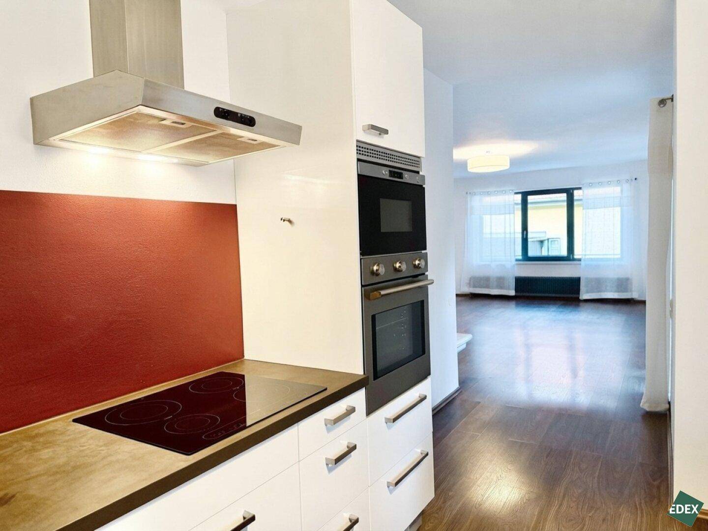 Offene Küche mit modernen Geräten und Blick in den angrenzenden Wohnbereich.