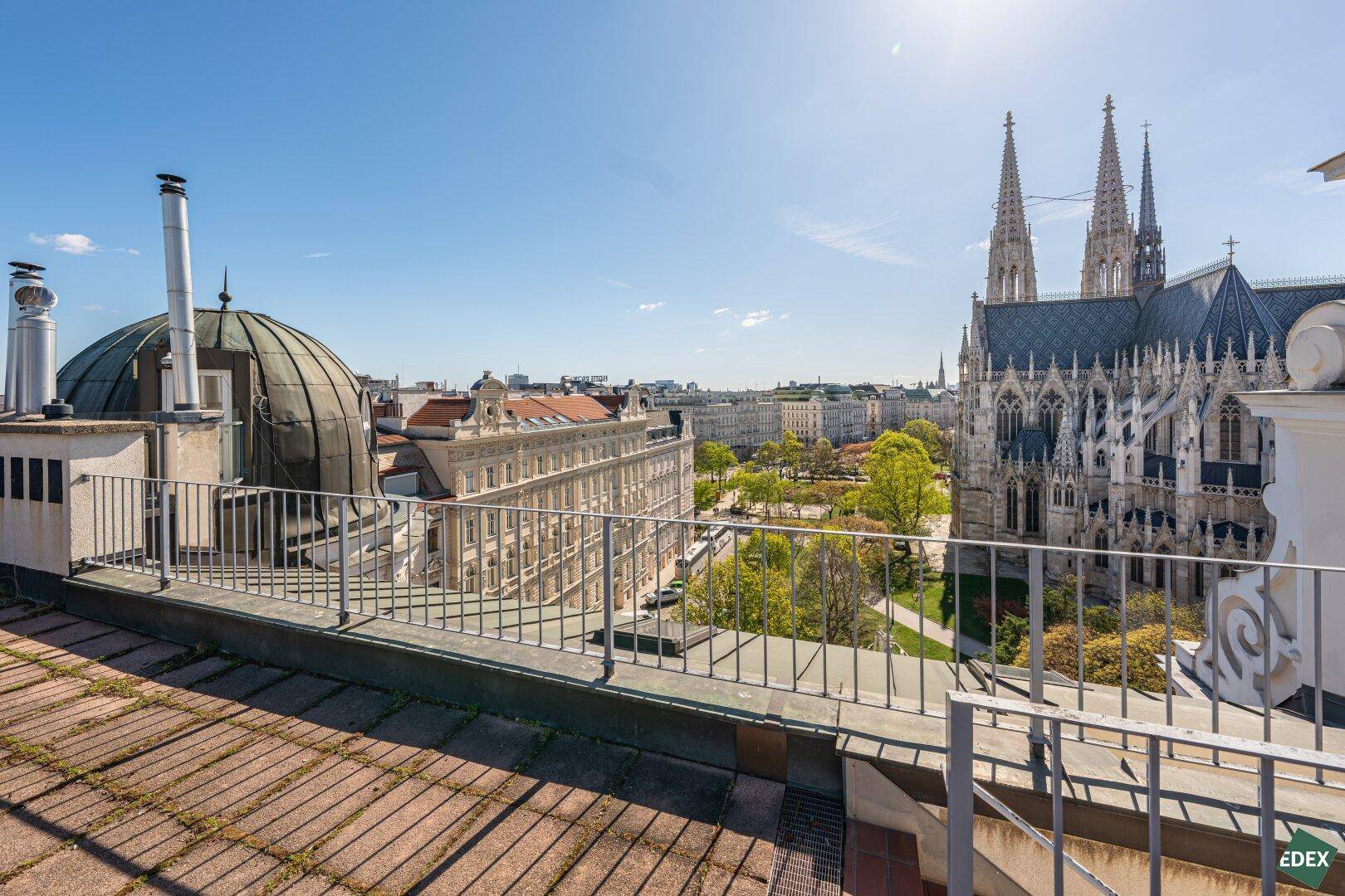 Geräumige Dachterrasse mit Panoramablick auf die Votivkirche und die Wiener Skyline.
