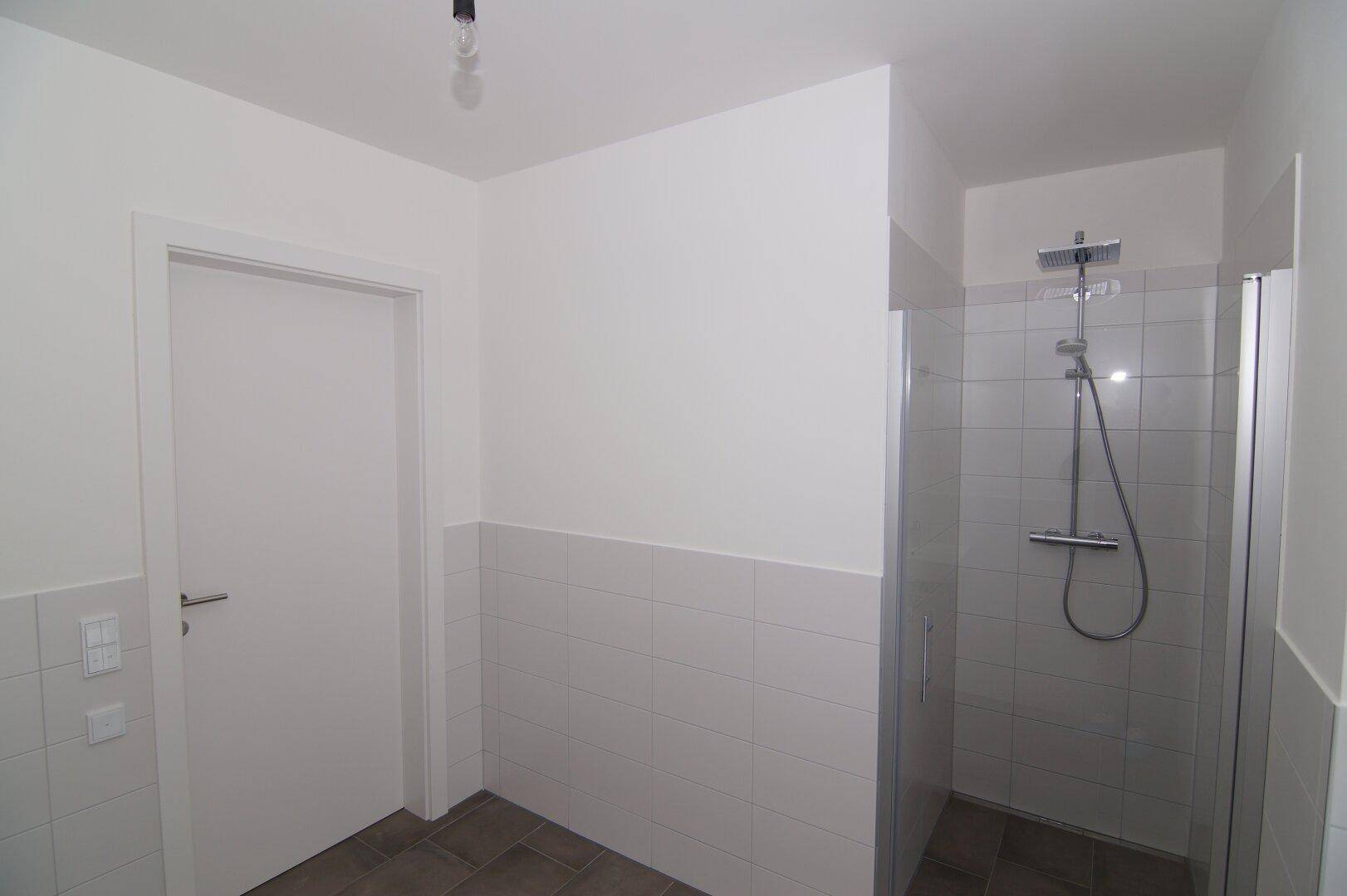 Geräumige Duschkabine mit Glasabtrennung und Regendusche in einem modernen Badezimmer.