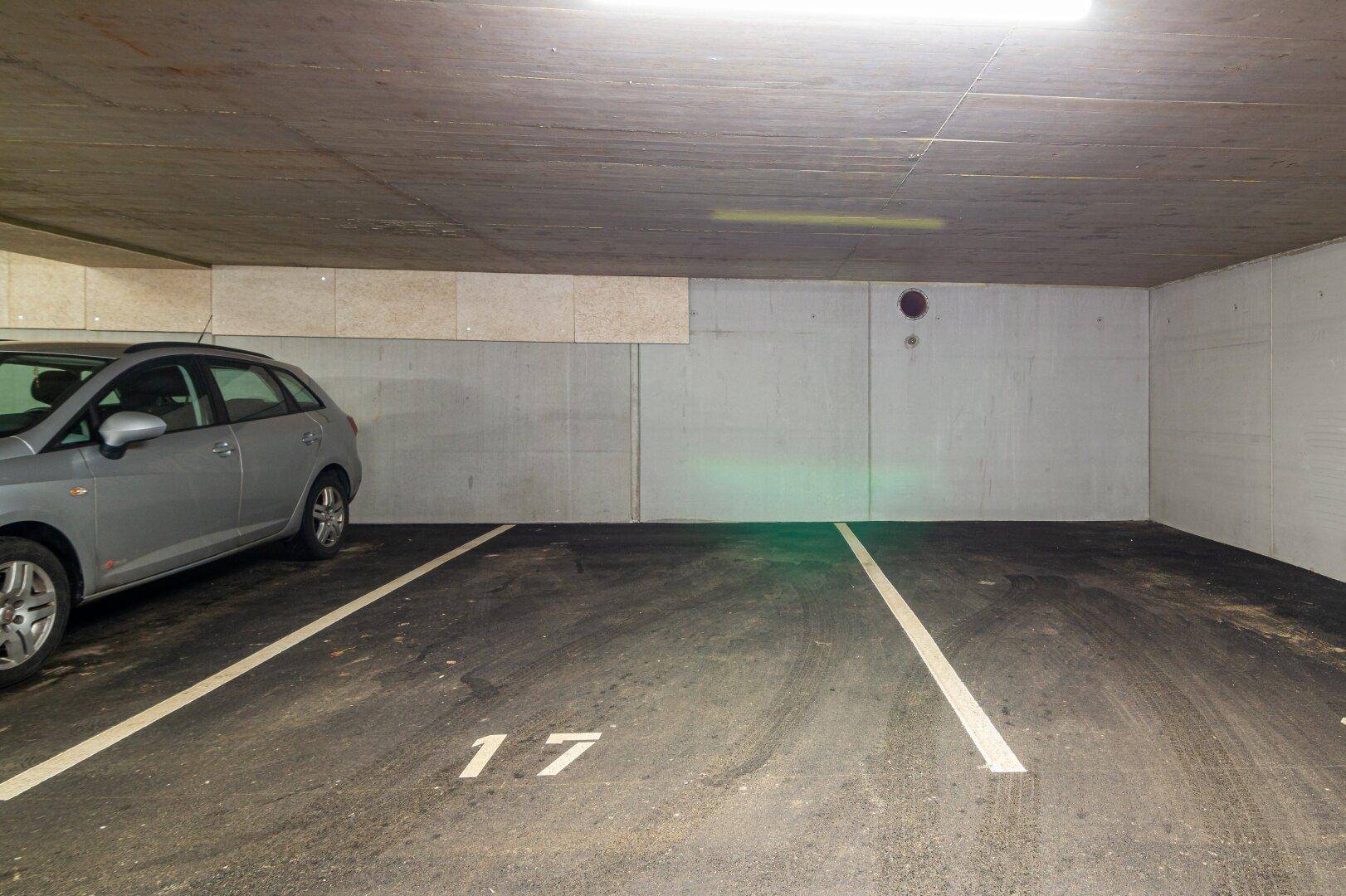 Freier Stellplatz Nummer 17 in der Tiefgarage neben einem geparkten Auto.