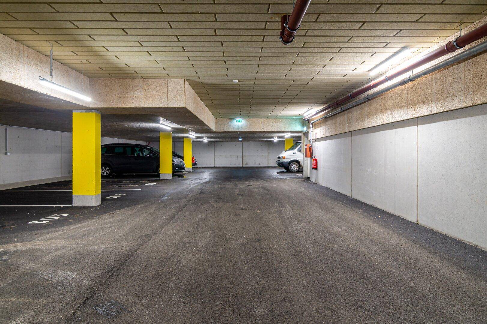 Geräumige Tiefgarage mit markierten Stellplätzen und guter Beleuchtung.