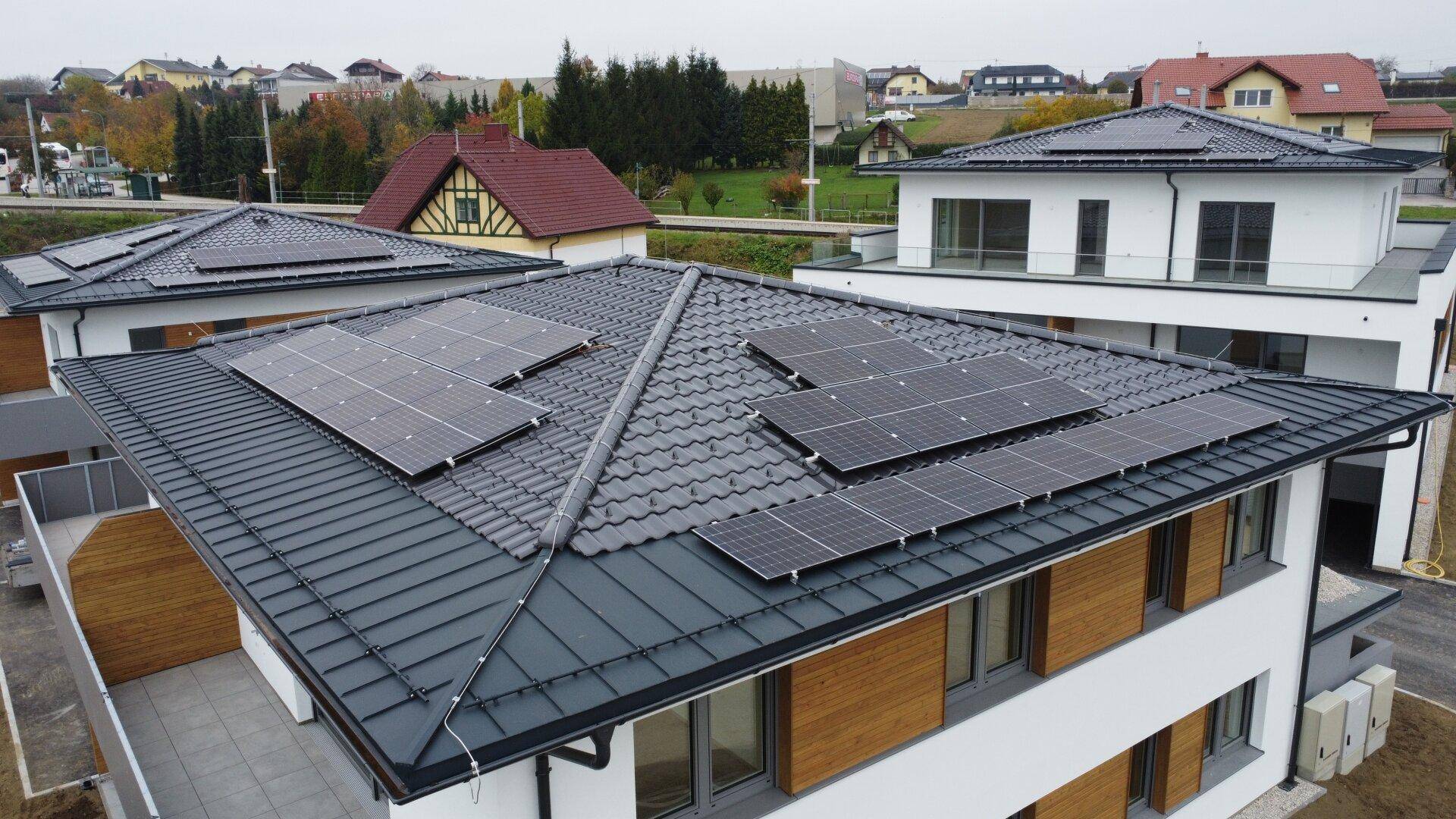 Nahaufnahme einer Photovoltaikanlage auf dem Dach eines modernen Neubaus.