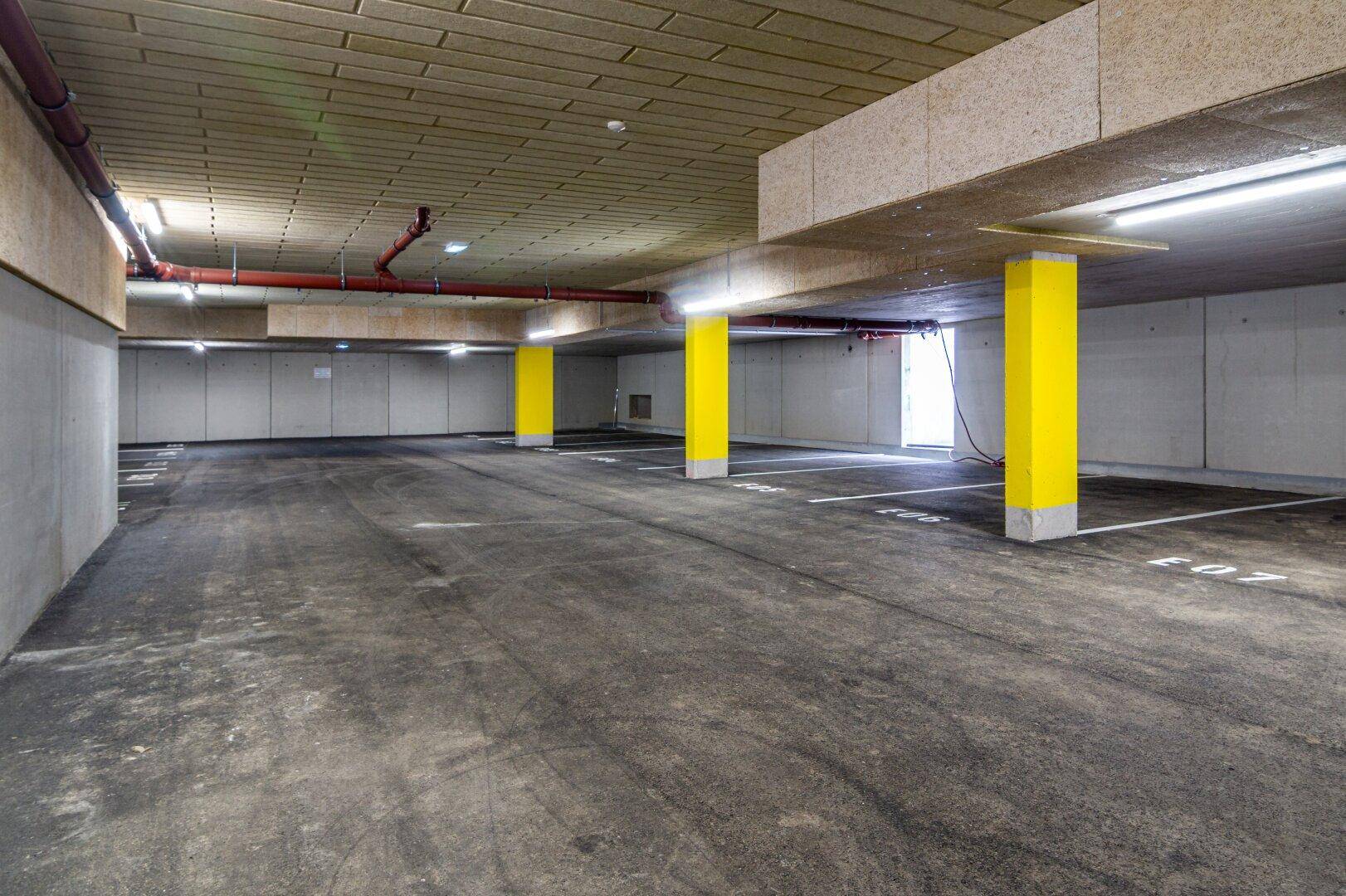 Geräumige Tiefgarage mit markierten Stellplätzen und guter Beleuchtung.
