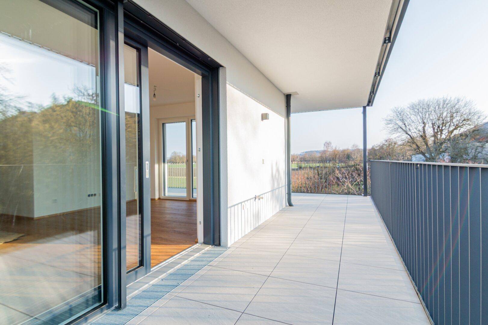 Geräumiger Balkon mit Fliesenboden und weitem Blick in die Natur, ideal zum Entspannen.