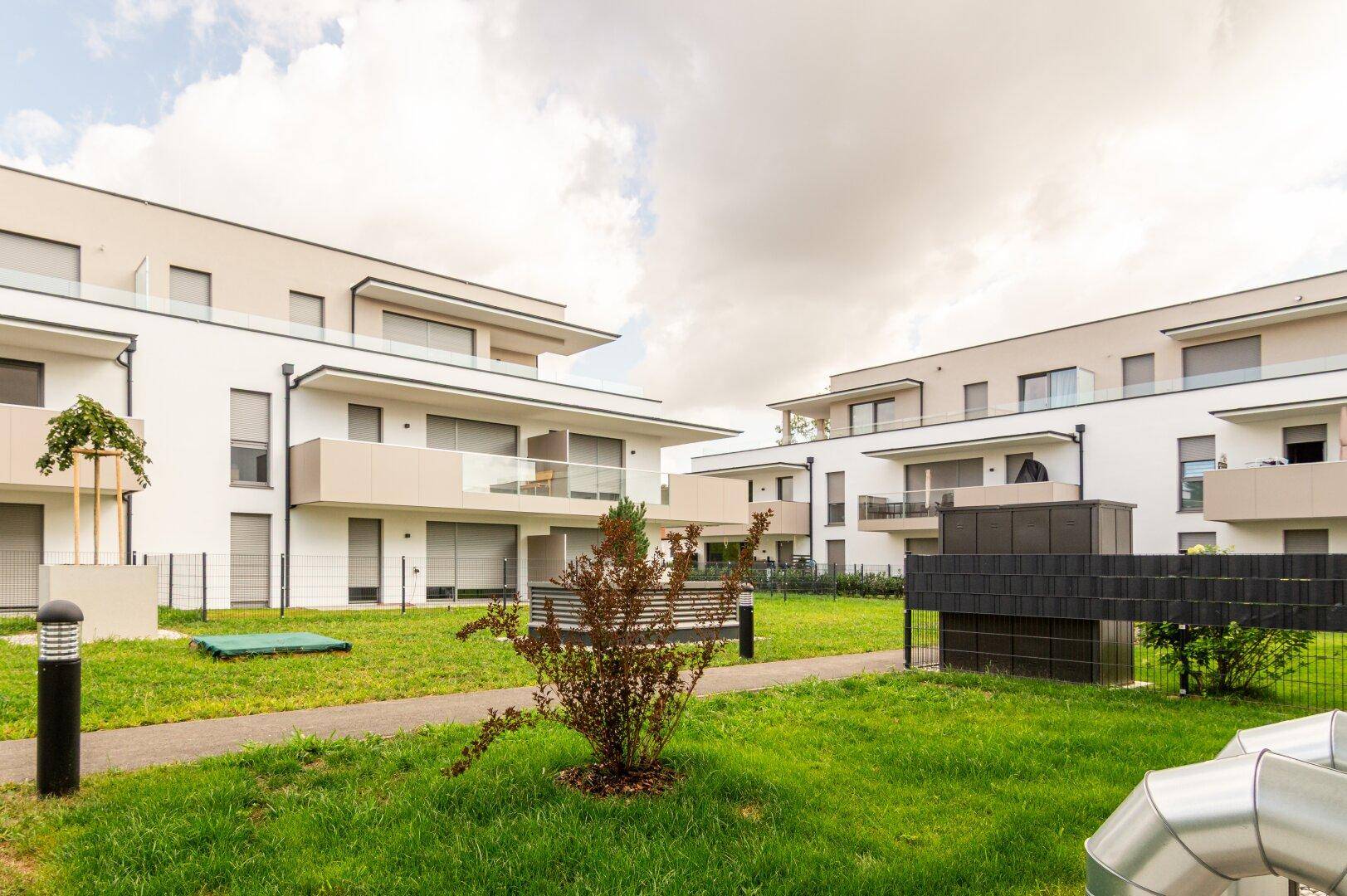 Moderne Wohngebäude mit Balkonen und gepflegten Grünflächen in einer Wohnanlage.