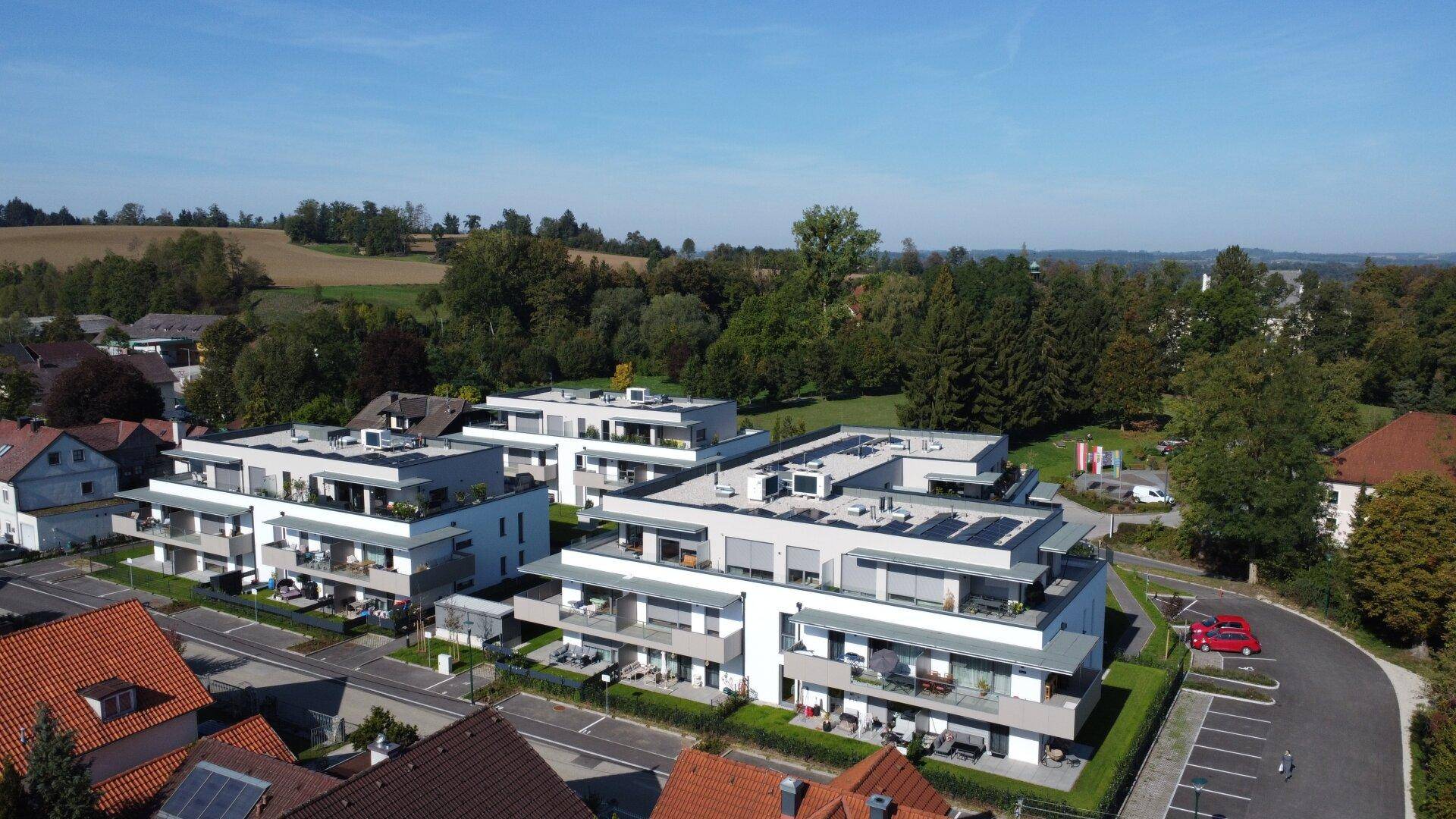 Weitläufige Ansicht der modernen Wohnanlage mit Balkonen und Terrassen in ländlicher Umgebung.