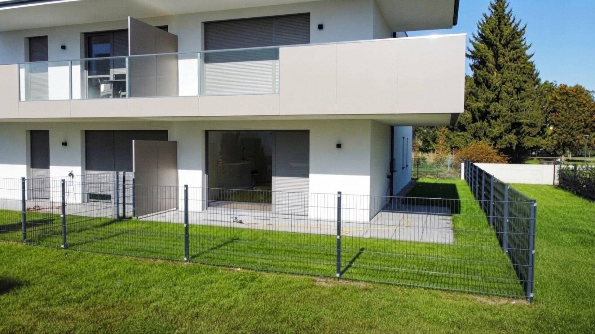 Moderne Erdgeschosswohnung mit privatem Gartenanteil und Terrasse, umgeben von Grünflächen.