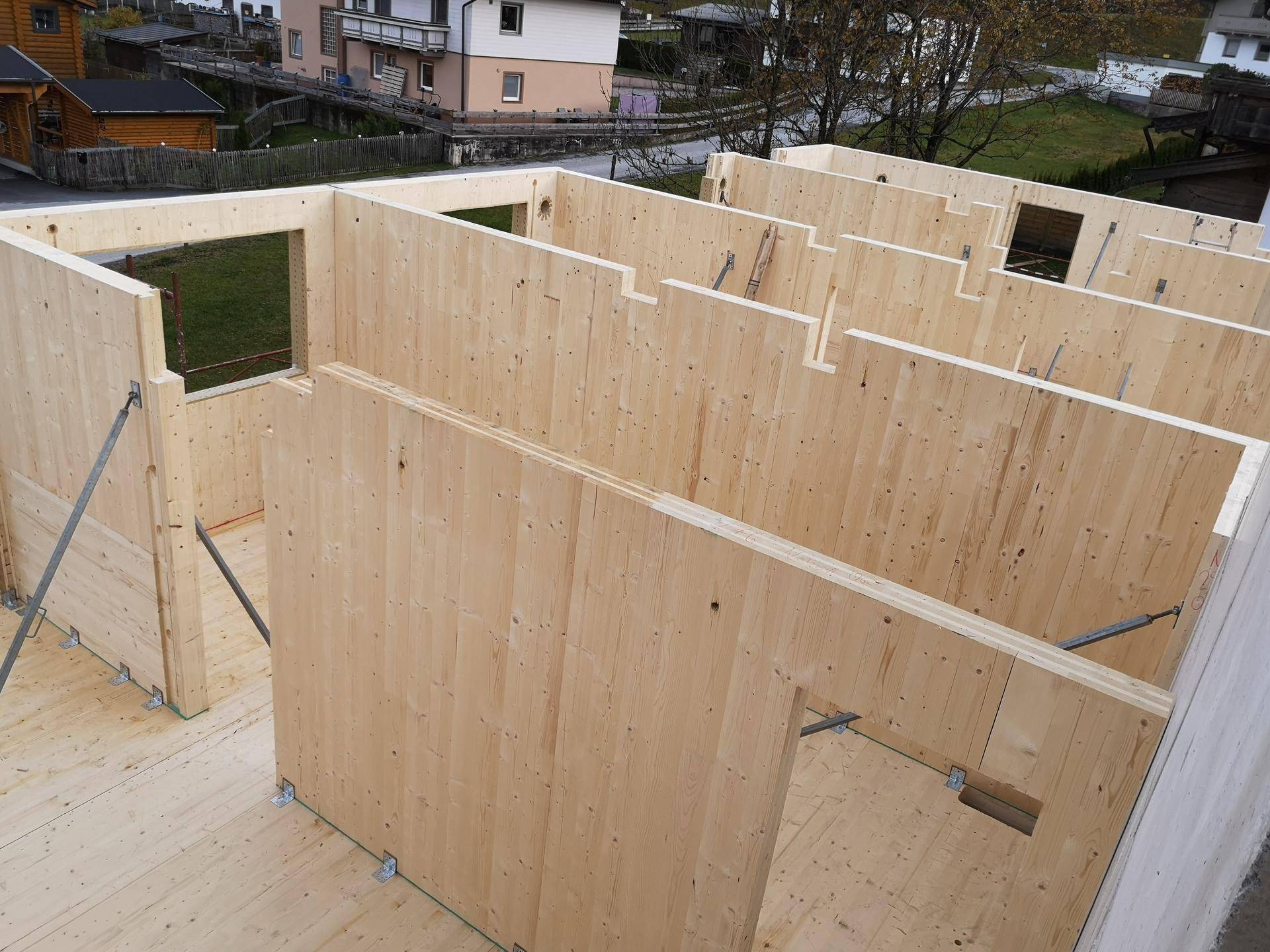 Holzrahmenbauweise eines Neubaus mit sichtbaren Wandelementen und Fensteröffnungen.