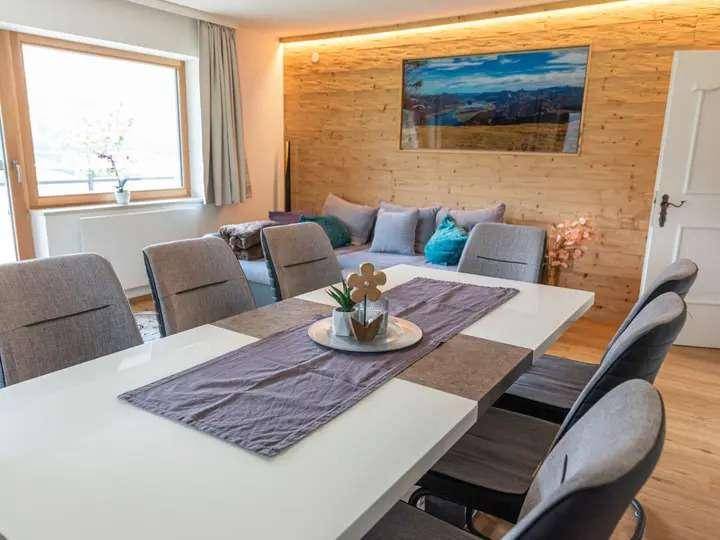 Heller Essbereich mit großem Tisch und Stühlen, angrenzend an den offenen Wohnbereich.