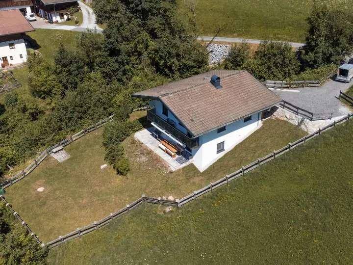 Luftaufnahme eines Hauses mit großem Garten und umliegenden grünen Wiesen in ländlicher Umgebung.