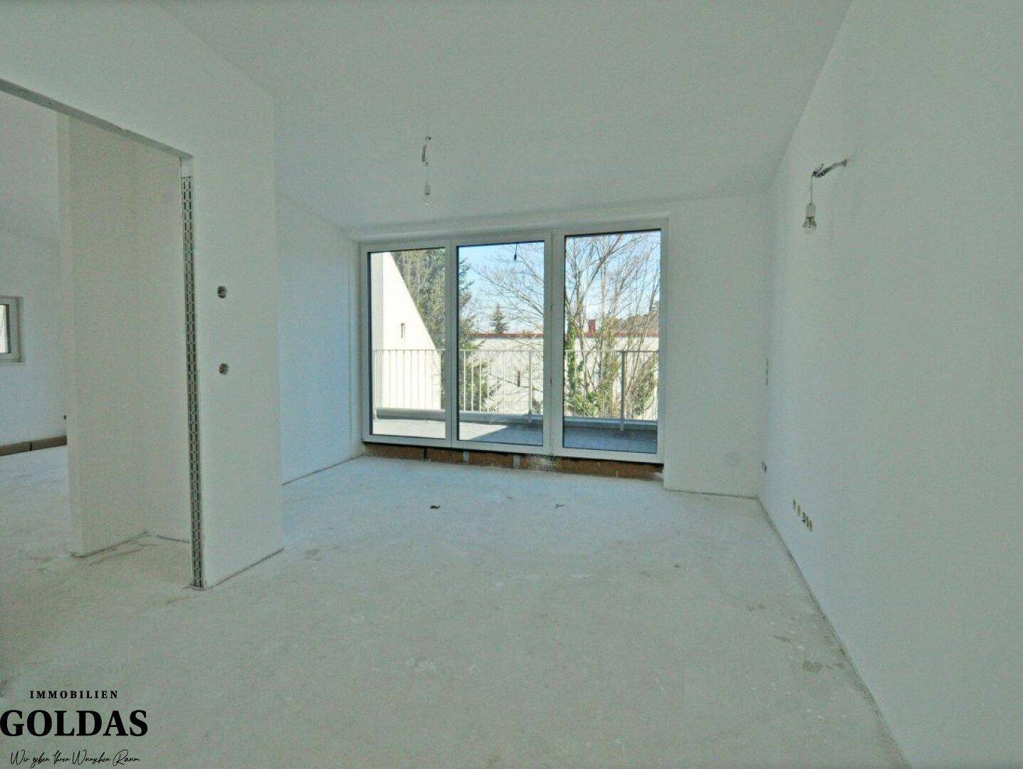 Heller Raum mit großen Fenstern und direktem Zugang zu einem Balkon mit Geländer.