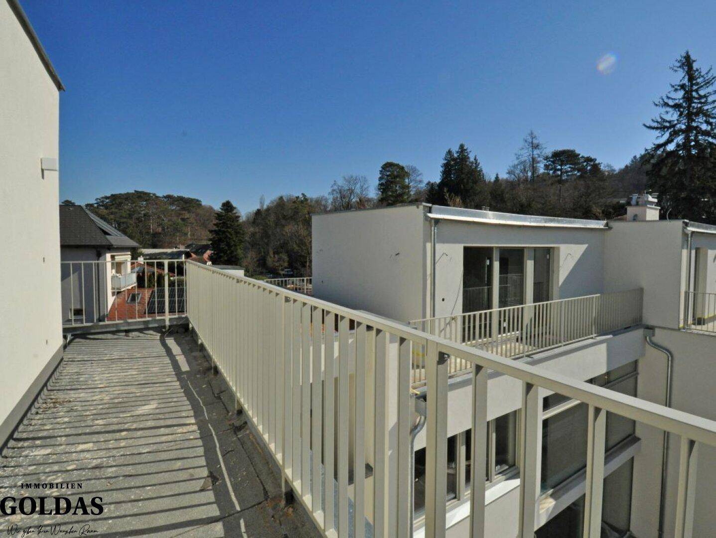 Geräumiger Balkon mit Geländer und Blick auf die umliegende grüne Landschaft.