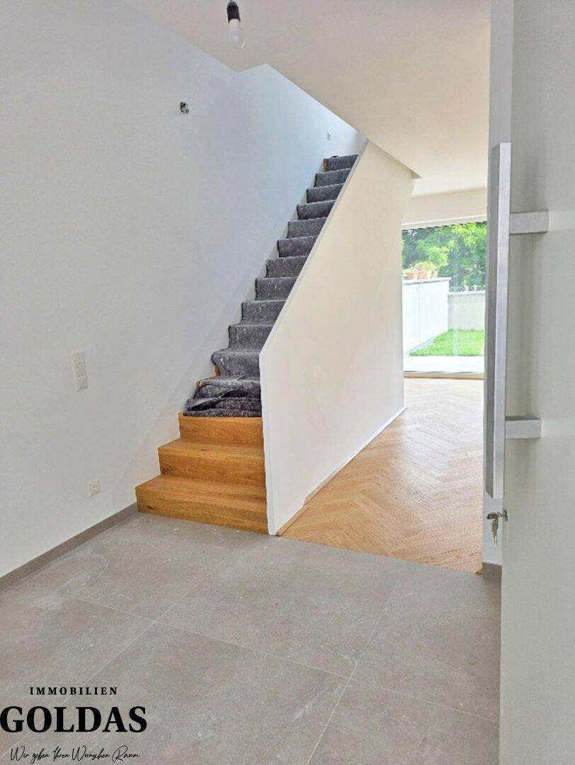 Heller Eingangsbereich mit moderner Treppe, einer Kombination aus Fliesen- und Parkettboden.