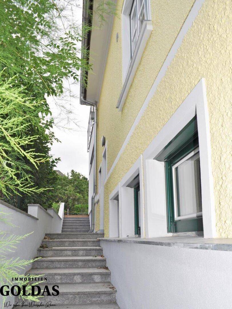 Außentreppe führt entlang der gelben Fassade zu den oberen Etagen des Gebäudes.