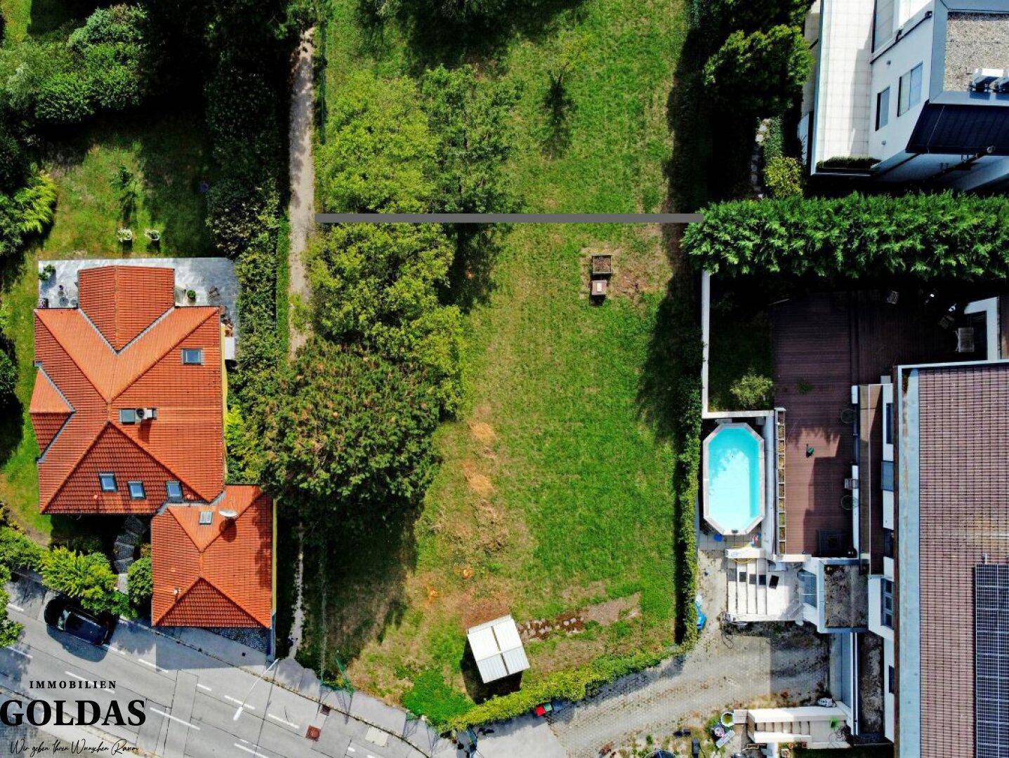 Draufsicht auf das grüne Grundstück mit angrenzenden Häusern und einem Pool auf dem Nachbargrundstück.