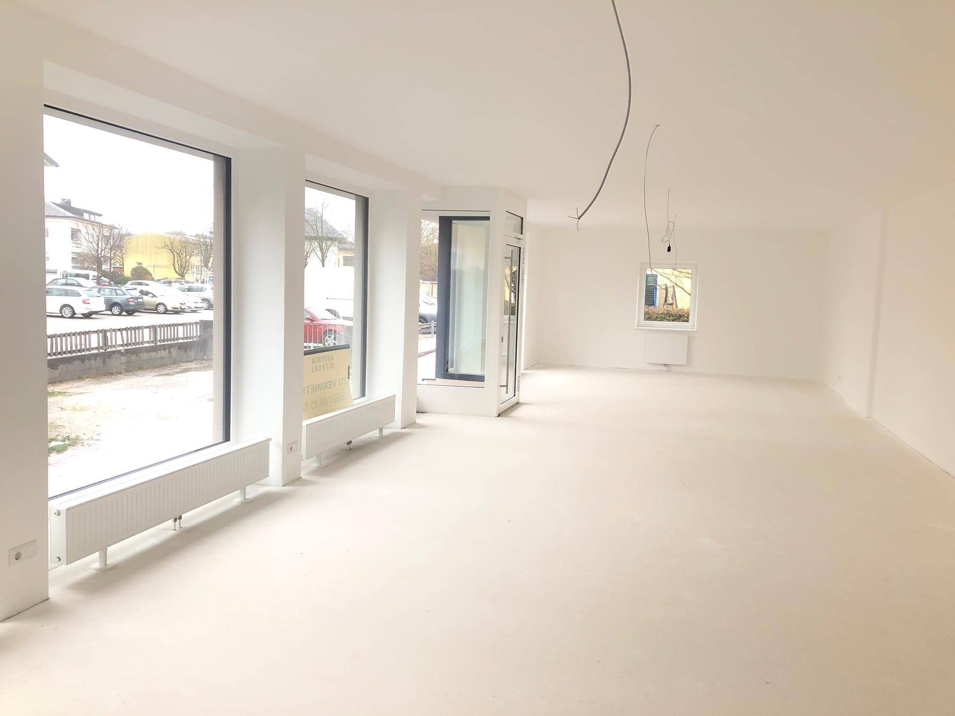 Heller, leerer Raum mit großen Fenstern, die viel Tageslicht hereinlassen, ideal für ein Geschäft oder Büro.