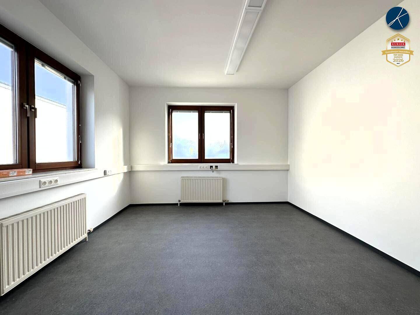 Heller Büroraum mit großen Fenstern und Heizkörpern, bereit zur individuellen Gestaltung.