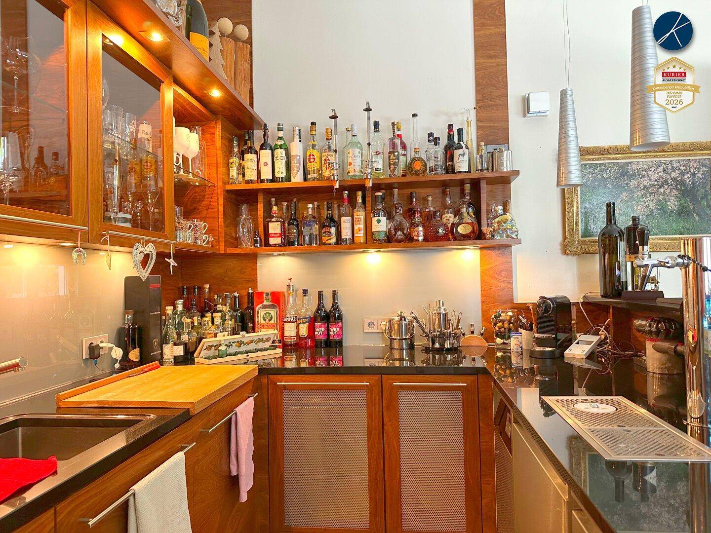 Gut ausgestattete Hausbar mit Holzschränken, Spüle und reichlich Flaschen.