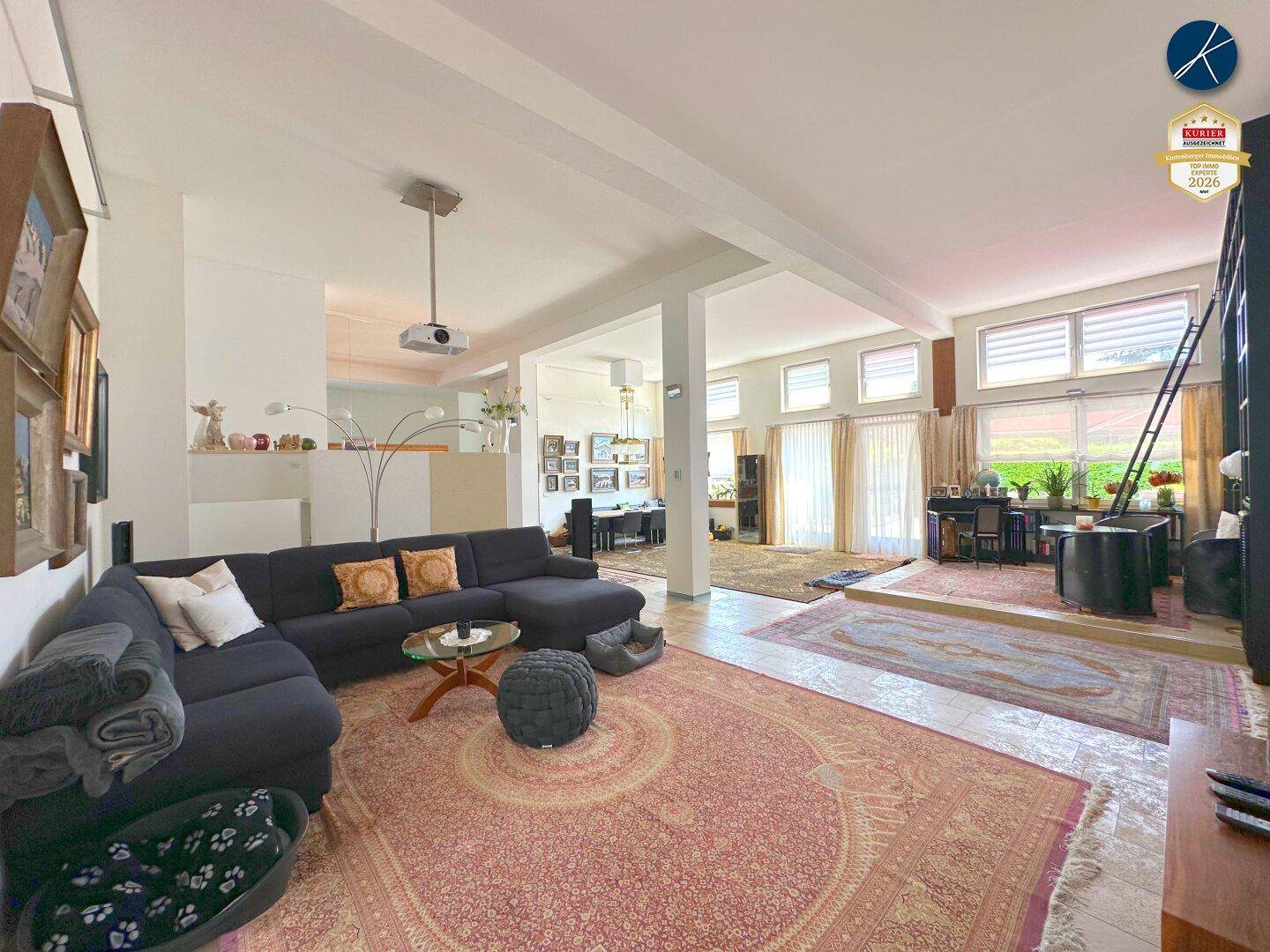 Großzügiges Wohnzimmer mit bequemer Couch, Teppich und offenem Grundriss.