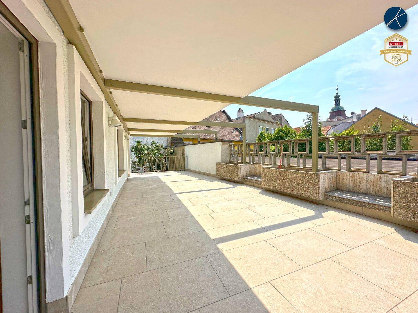 Weitläufige Terrasse mit Blick auf die Umgebung und historische Gebäude, perfekt für sonnige Tage.