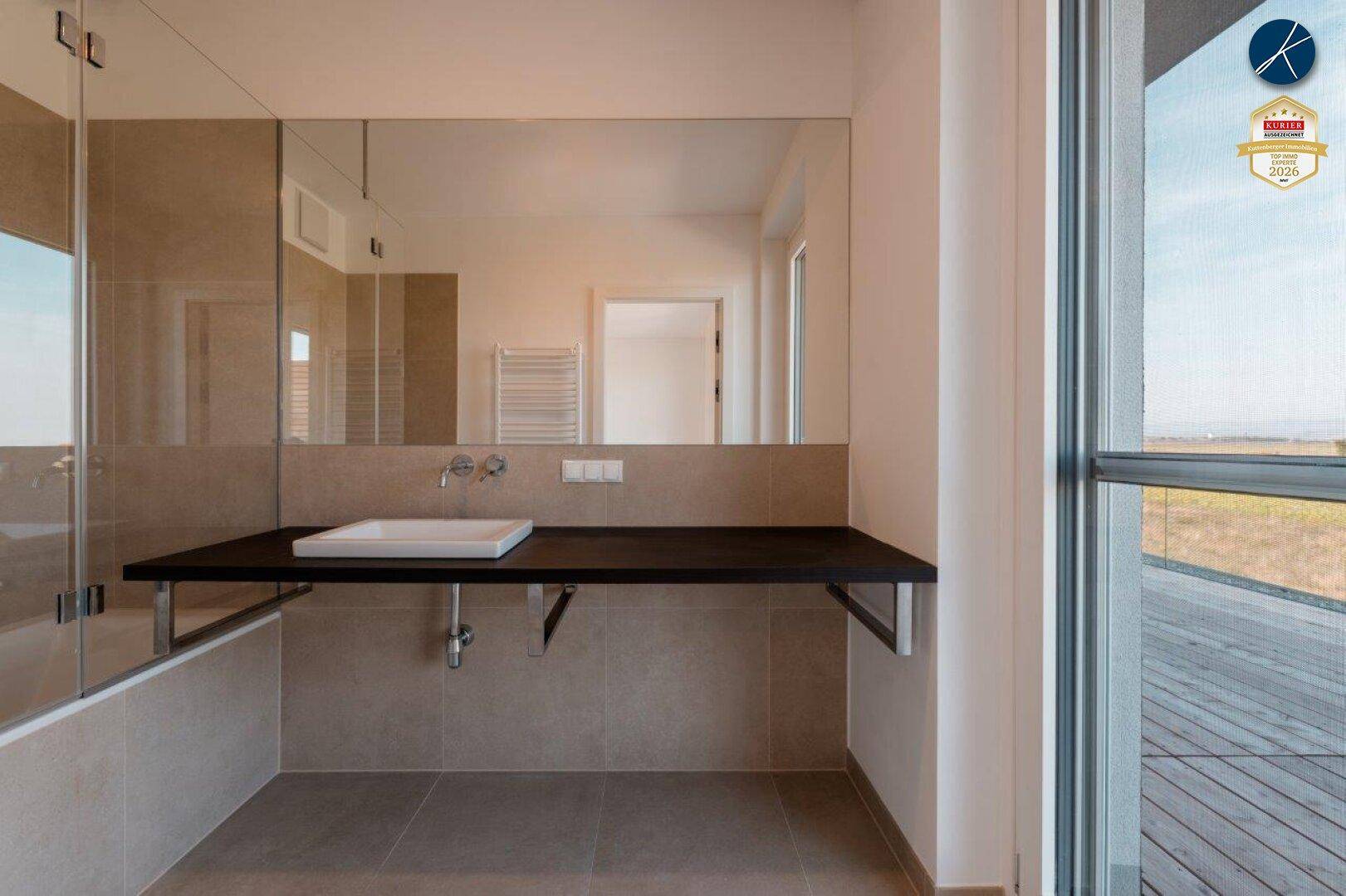 Modernes Badezimmer mit großem Spiegel, Einzelwaschbecken und begehbarer Dusche.