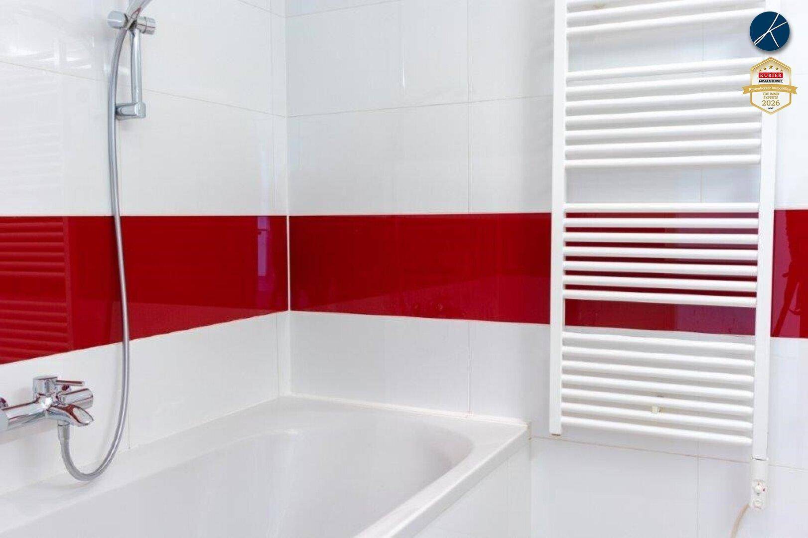 Badezimmer mit Badewanne, Duscharmatur und einem weißen Handtuchheizkörper.