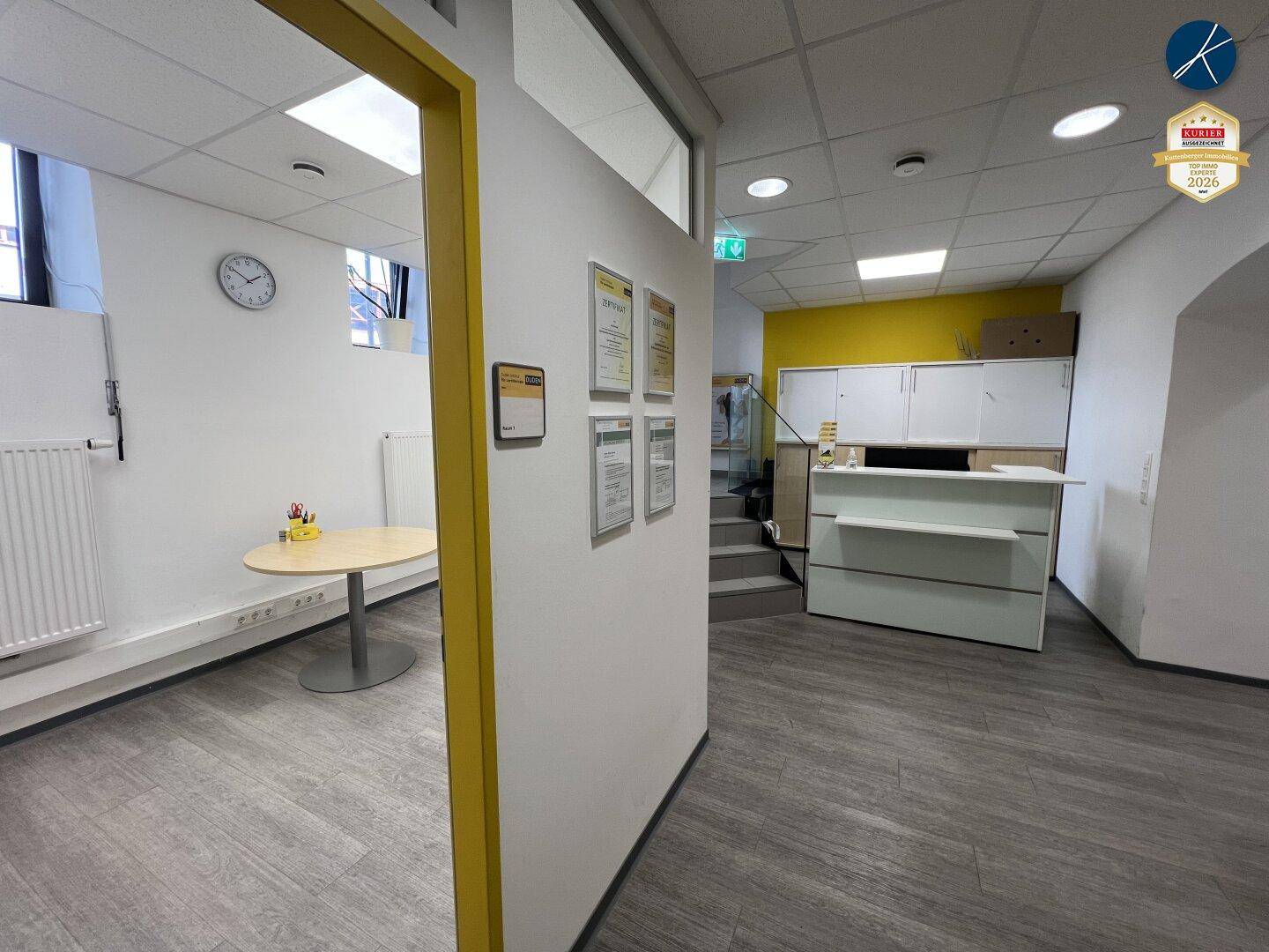 Empfangsbereich mit Theke, Wartebereich und Zugang zu weiteren Büroräumen.