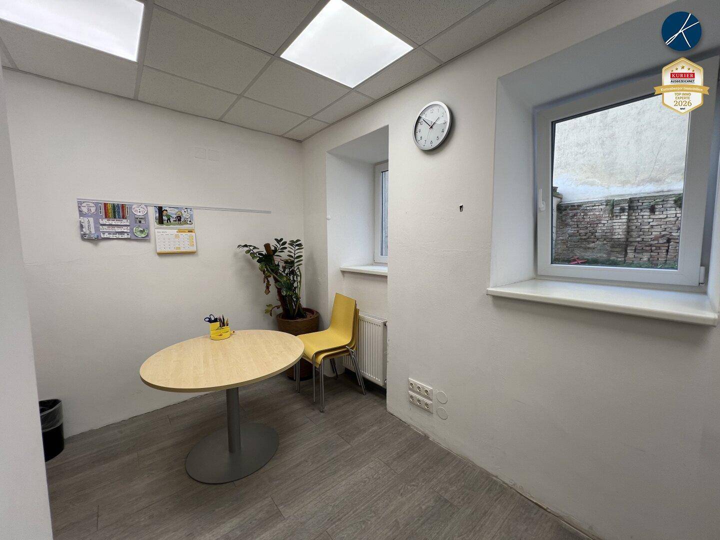 Kleiner Büroraum mit Tisch, Stuhl und Fenster, bietet eine ruhige Arbeitsumgebung.